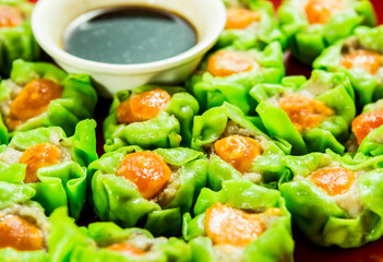 Man keeping dumpling to dip in sauce , in studio Chiangmai Thailand