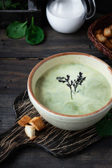 Creamy soup puree with spinach on a dark background
