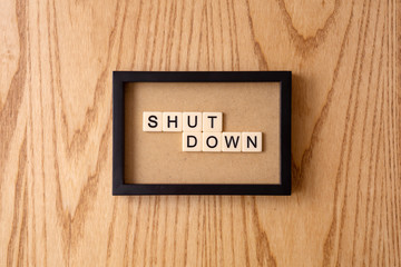 SHUTDOWN word block on wood background. 