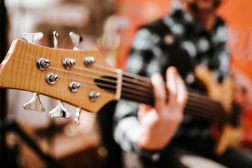 Fototapeta premium Photo of musician playng on six string fretless bass guitar on the street in front of people.