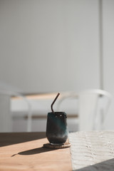 black beverage drink made from charcoal and milk on vintage style wood table