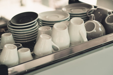 White coffee cups are placed on top of the coffee machine.