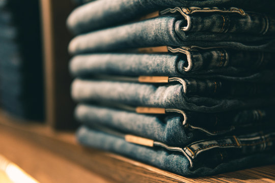 Stacked jeans with multiple waist sizes on shelves or closets and Selective focus.