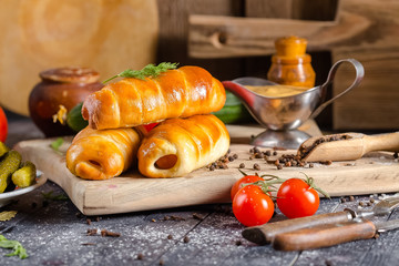 pies, loaf bread, dough on a wooden vintage cutting board old rustic, mustard sauce-dish, tomato,...