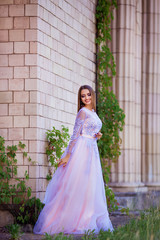 Fototapeta premium Fashion outdoor photo of beautiful sensual girl with dark hair in elegant dress posing in ancient architecture.