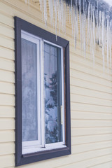 Icicles hang from the roof of a private house in winter