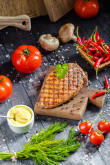 grilled kebab grilled meat steak lies on a wooden vintage old board rustic, chili, with tomatoes,...