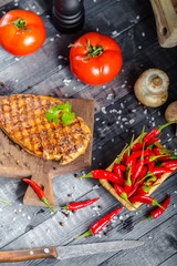 grilled kebab grilled meat steak lies on a wooden vintage old board rustic, chili, with tomatoes,...