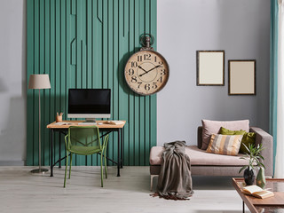 Green wall and grey wall together in the room, working table computer and clock frame decoration.