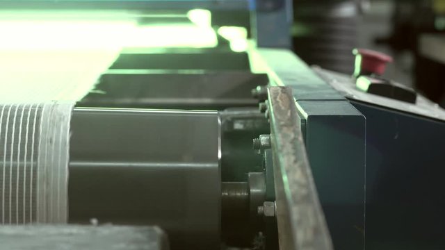 Close-up Of An Industrial Dryer Conveyor Is Spinning In A Print Shop
