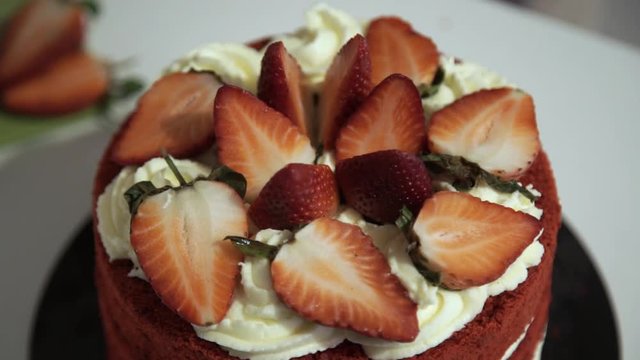 Making red velvet cake at home. Decoration of the cake with strawberries and cream. Large frame