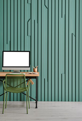 Green wall background with wooden table and computer style.