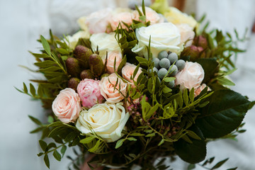 bridal bouquet in the hands against the background of the dress