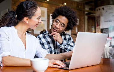 Multiethnic people meeting at cafe, advisor showing offer to client on laptop