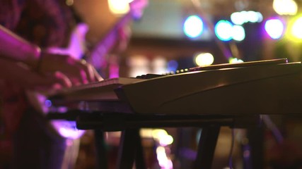 Playing keyboard in music band at night festival light