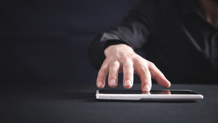 Man in black office desk with a tablet computer.