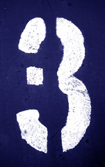 Number 3 in stencil on metal wall in blue tone.