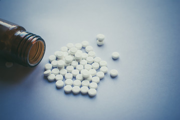 Addiction. White pills with a glass brown bottle. Heart shape. tablets