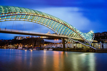 The bridge of peace in Tbilisi, Georgia. Beautiful lighting of the friendship bridge by night. The main attraction of the town.