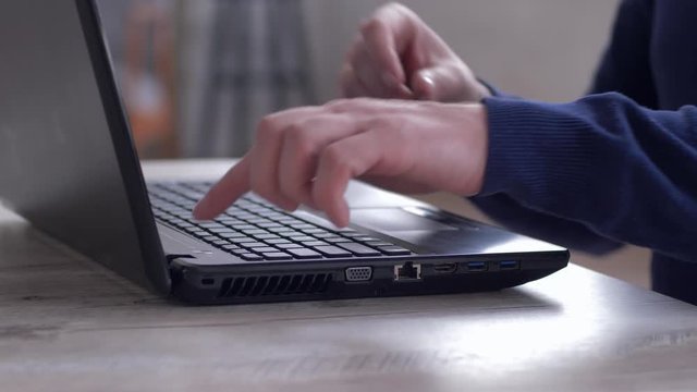 man hand presses the power button and connect usb flash drive to laptop for copying information