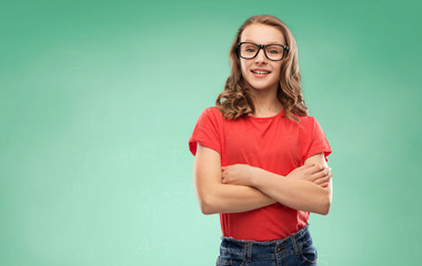 education, school and people concept - smiling teenage student girl in glasses and red t-shirt with crossed arms over green chalk board background