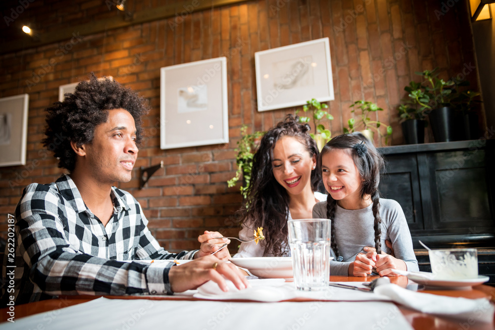 Wall mural happy african american family eating lunch together at restaurant and having fun