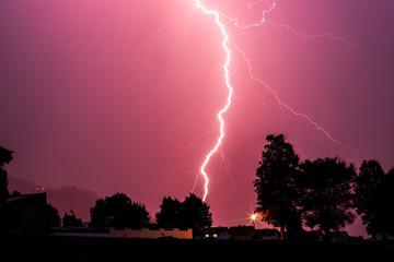 Thunderstorm in the night: Lightning on the colored sky. Global warming.