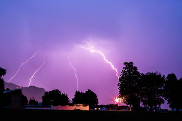 Thunderstorm in the night: Lightning on the colored sky. Global warming.