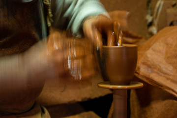 Craftsman artist making craft, pottery, sculptor from fresh wet clay on pottery wheel, long exposure