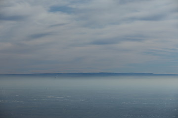 Landschaft Rheinebene mit Windrädern unter einer Nebeldecke und Wolkendecke