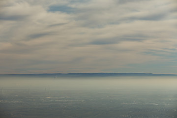 Landschaft Rheinebene mit Windrädern unter einer Nebeldecke und Wolkendecke