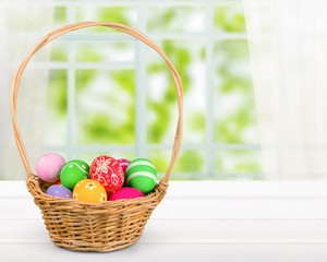 Easter basket filled with colorful eggs on a white background