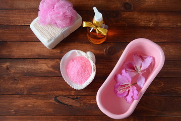 Spa and body care products. Aromatic rose bath Dead Sea Salt on the dark wooden background. Natural ingredients for homemade body salt scrub. Dead Sea cosmetics. Beaty skin care. Spa treatment