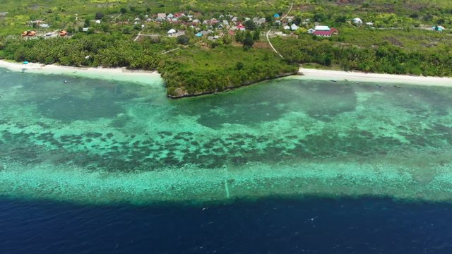 Aerial: Flying over tropical beach turquoise water coral reef , Tomia island Wakatobi National Park Indonesia Maldives Polynesia white sand beach