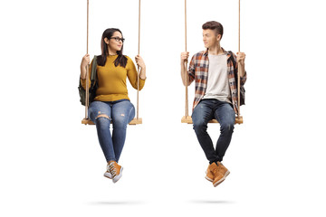 Female and male student on a swing looking at each other