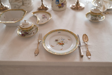 Wedding table decoration with expensive retro royal majesty porcelain service plates and cutlery in a palace