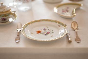 Wedding table decoration with expensive retro royal majesty porcelain service plates and cutlery in...