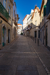 a street in Sesimbra with its houses and blue sky in the background