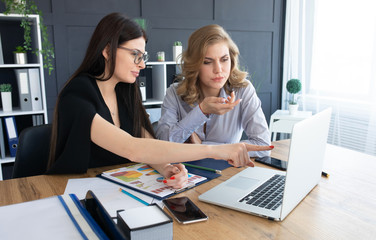 Two business woman investment consultant analyzing company annual financial report balance sheet statement working with documents graphs. Concept picture of economy, market, office, money and tax.