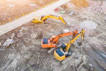 Three excavators on caterpillars in the foundation pit during the construction of the building...