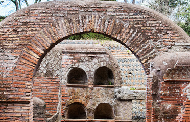Roman necropolis  columbarium graves in Ostia Antica ruins and view of the arch