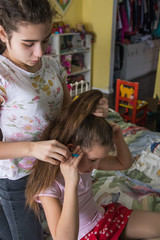 Young Girl Braiding Her Friends Hair. Criyng girl during braiding hair