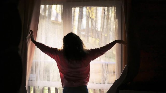 Woman Opens curtains and the Door to the Balcony Overlooking the Forest on sunny autumn day. slow motion. 3840x2160