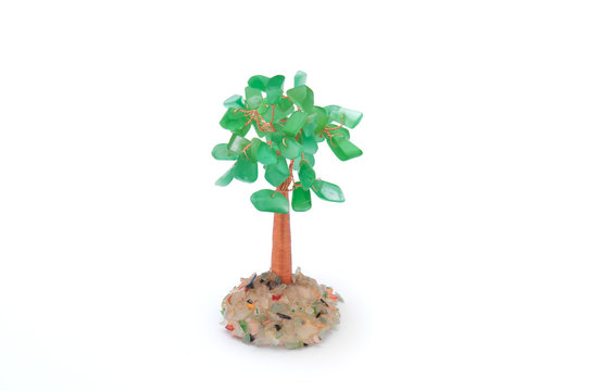 money tree of green stone with coins on a white background.