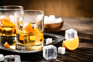 Old fashioned cockatil and ingredients on rustic background