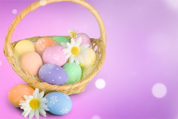 Easter basket filled with colorful eggs on a white background
