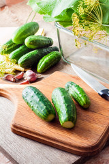 Fresh cucumbers on wooden board prepared for pickling