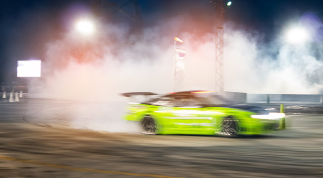 Blurred of speed car drifting on racing track at night.