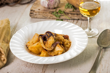 Chocos con patatas y copa de vino blanco