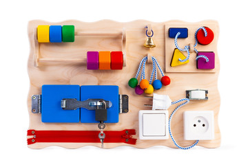  educational toy for children, babies on a white isolated background, consisting of a sorter, a zipper for clothes,  switch, beads, a labyrinth, a lock with a key, roller, bell, rosette